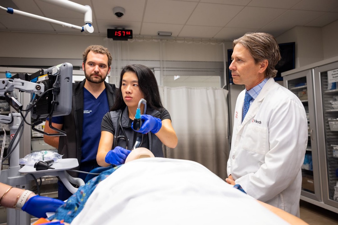 Attending physician teaching resident how to use a scope