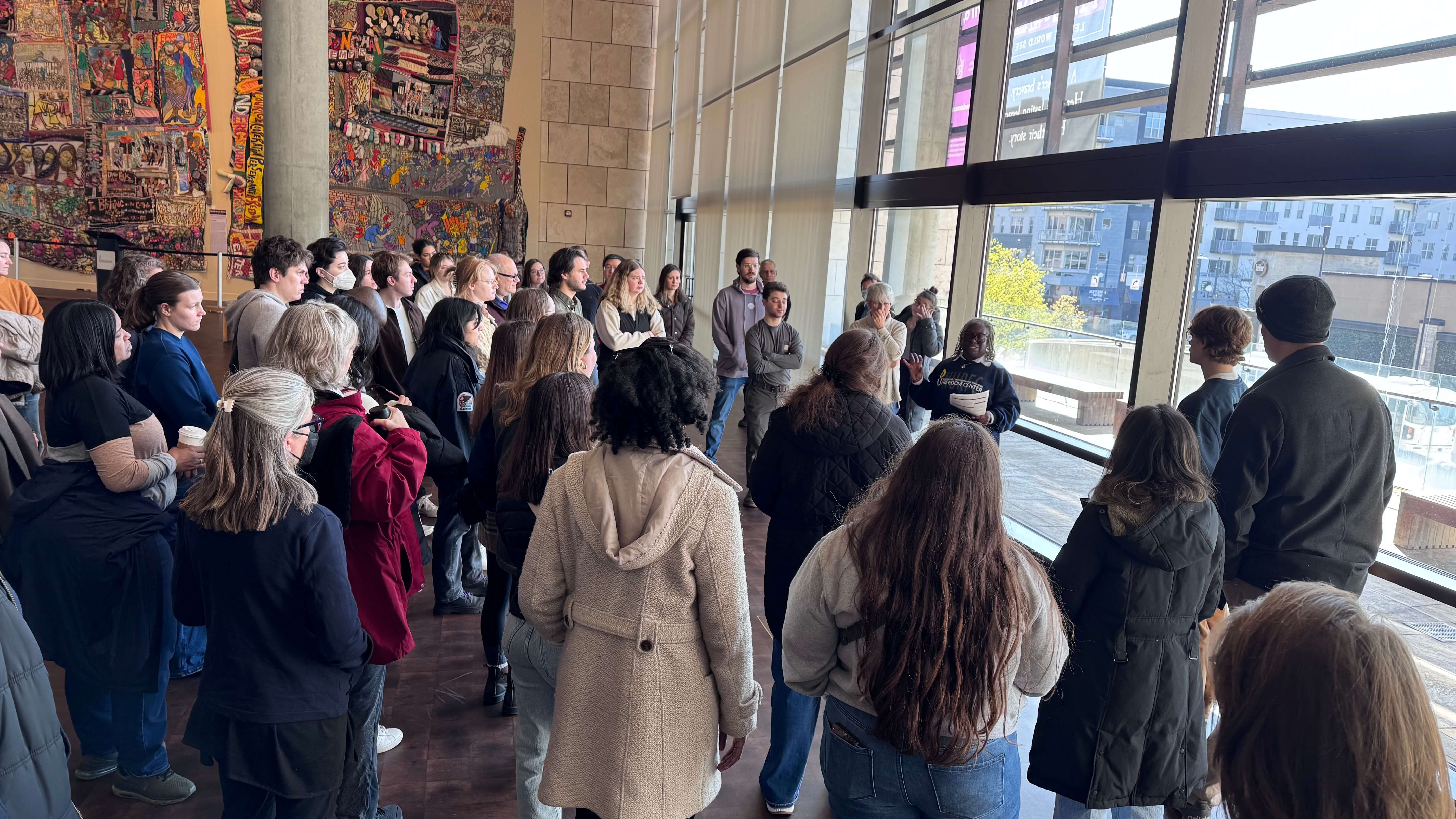 people gathered listening to a tour guide at a museum