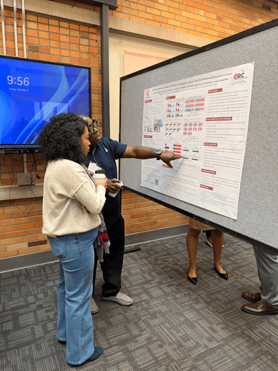 Two poeple discuss images on a poster