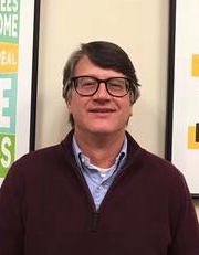 Headshot of man standing in front of a wall