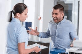 man yelling at a woman behind a desk