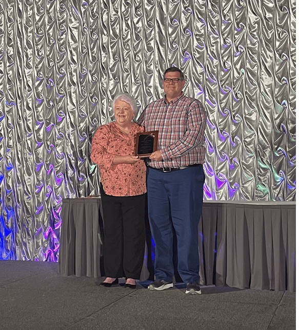 two people on stage presenting an award