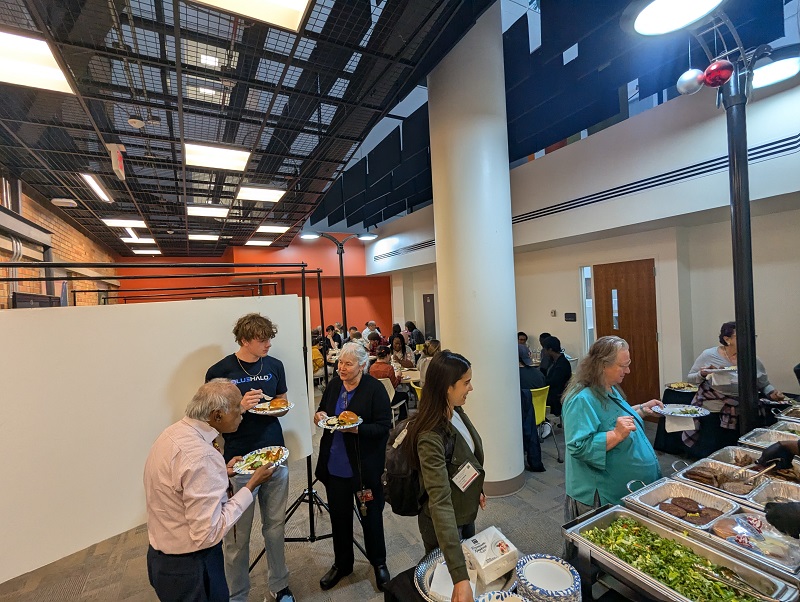 attendees gather to eat dinner and view posters