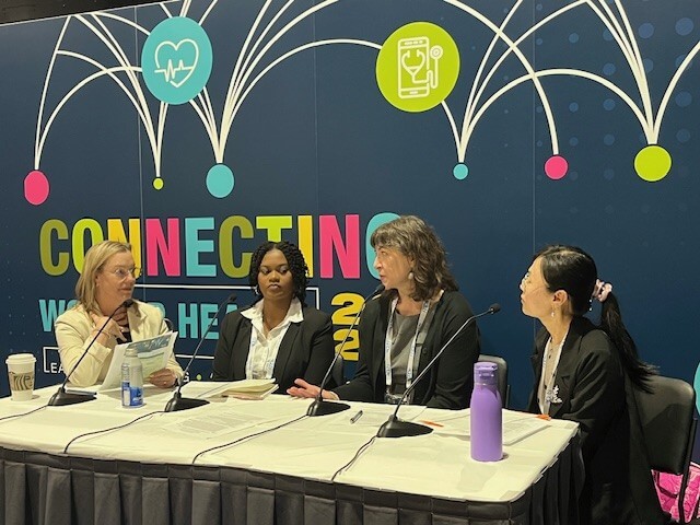 4 people sitting at a table with microphones