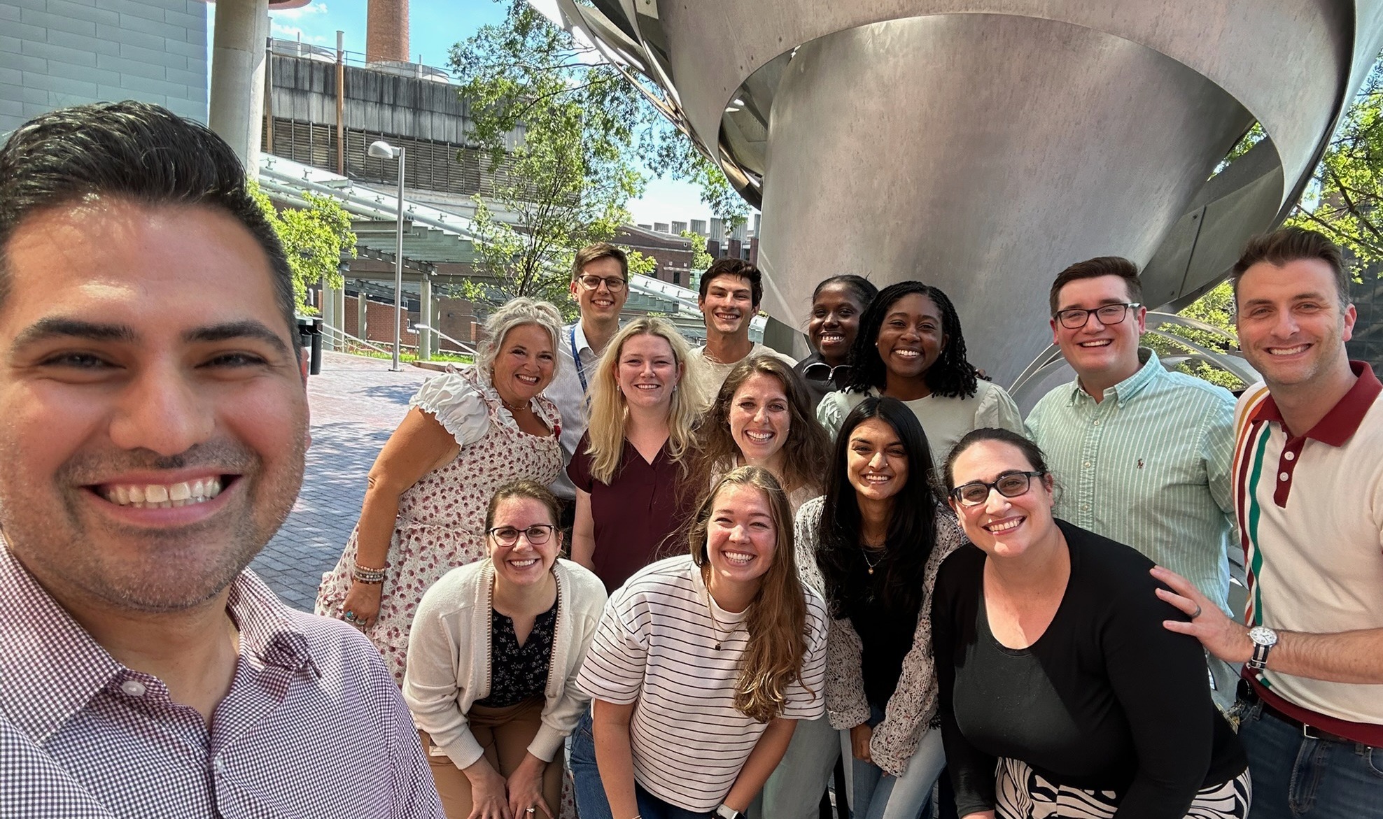 Selfie picture of the Med-Peds Leadership Group and the Class of 2030 outside in front of a sculpture.