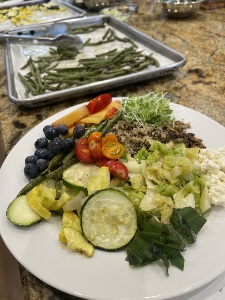 plate of completed quinoa bowl dish and cooked vegetables on a cooking tray