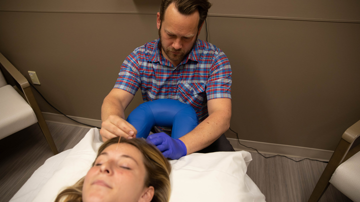 acupuncturist providing acupuncture to patient