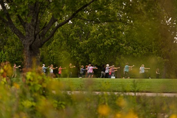 group of people doing tai chi in nature at Ault Park