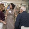 Two women conversing with others mingling in the background