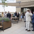 The rooftop garden filled with groups of people mingling with drinks and appetizers