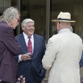 A smiling man talking to a group of people in the garden
