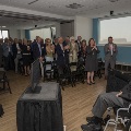 A room full of people giving a standing ovation to a speaker