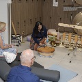 People seated on yoga mats enjoying sound immersion led by a women with instruments