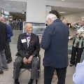 A seated man is welcomed by guests