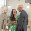 Three people mingle in a kitchen
