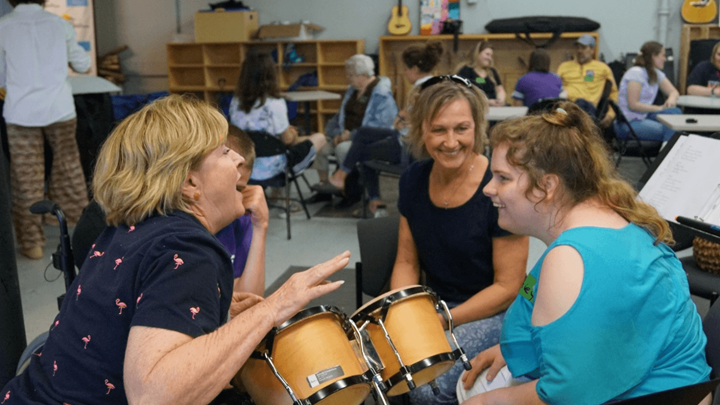 women sitting in a group creating music