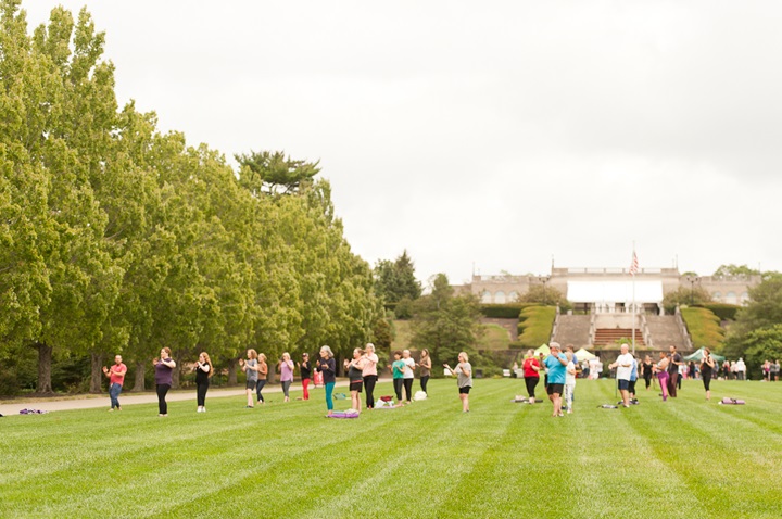 A group of people doing Tai Chi in Ault Park with fountain in background