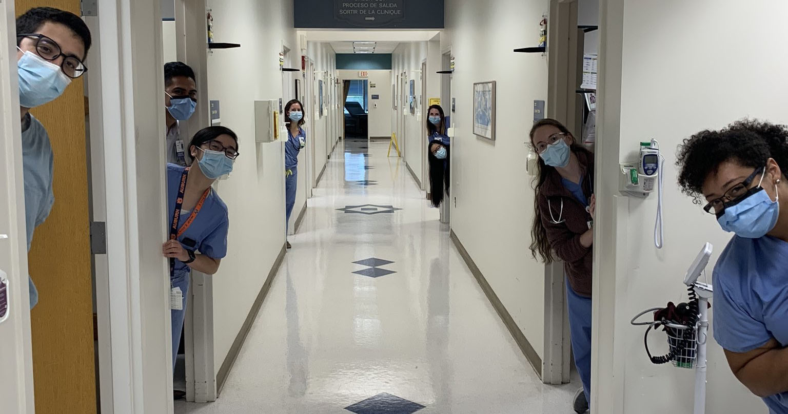 People peeking out of doors in hallway