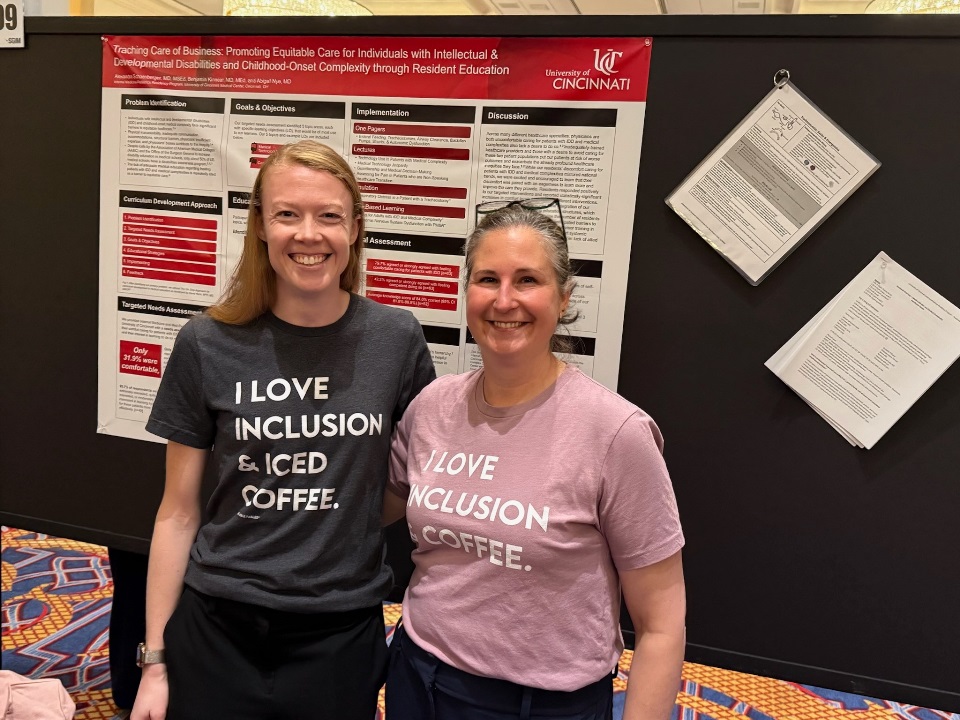 Two Med-Peds docs in front of poster